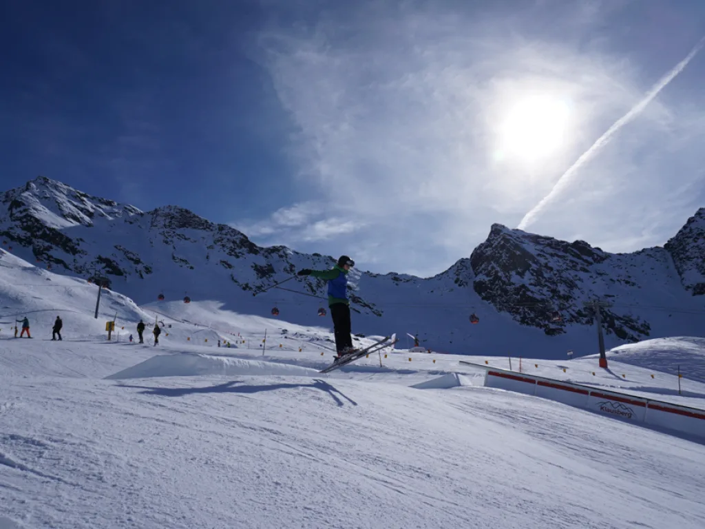 Skifahrer auf der Piste gegen die tief stehende Sonne.